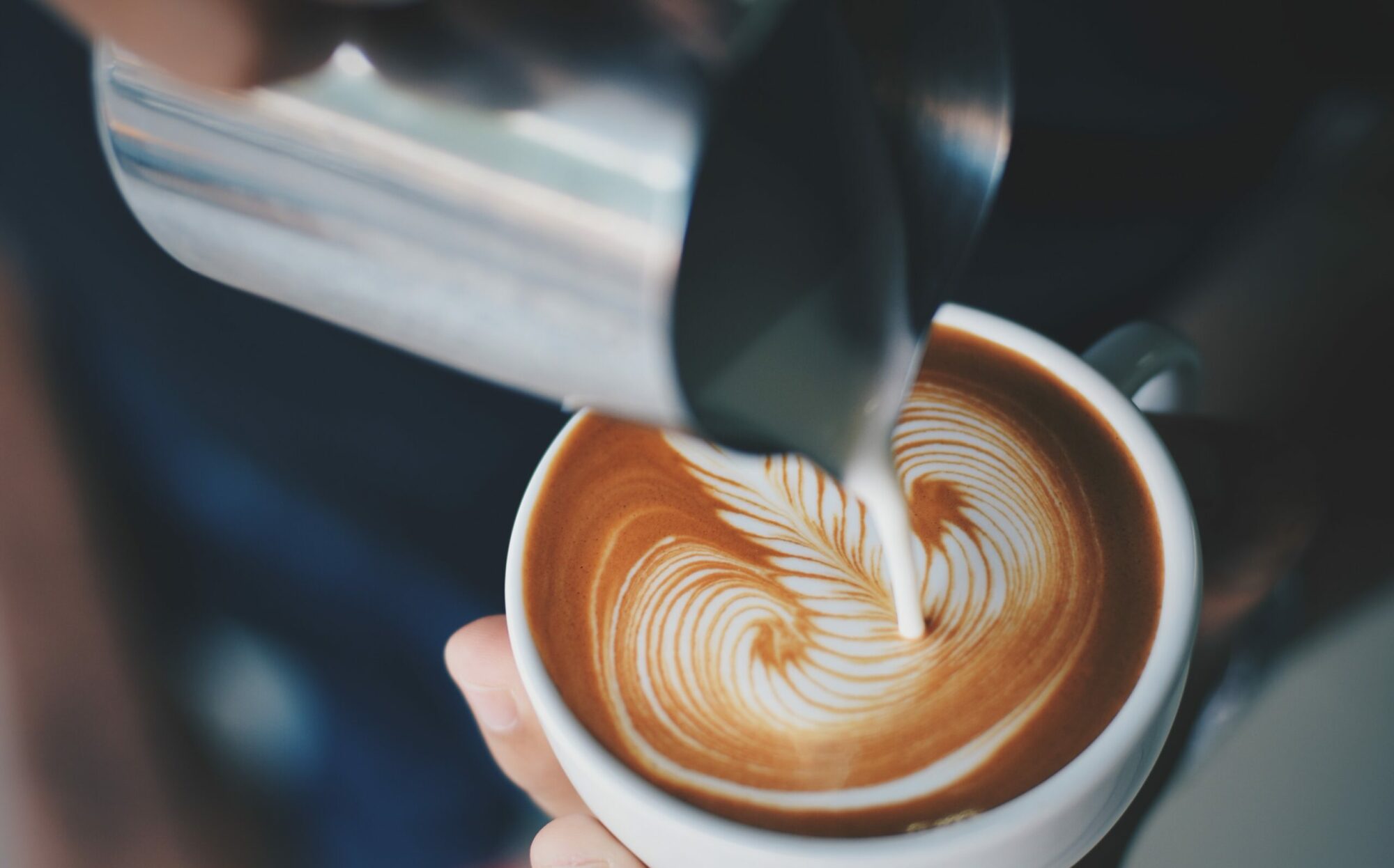 Café fraîchement versé, coulant lentement dans une tasse, créant une ambiance chaleureuse et accueillante.