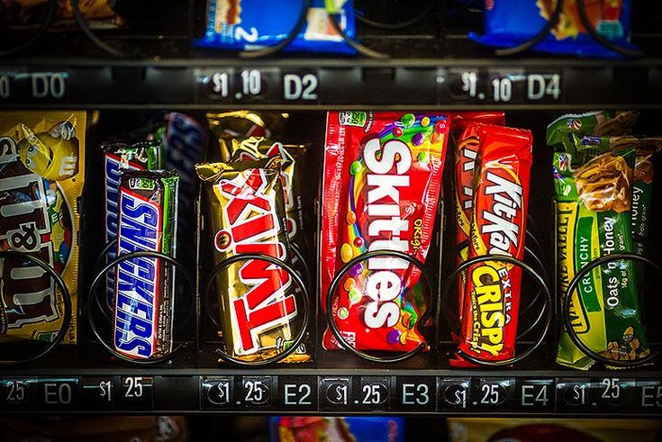 Assortiment de snacks populaires, dont Twix, Snickers et autres gourmandises, idéal pour remplir les distributeurs automatiques en entreprise.